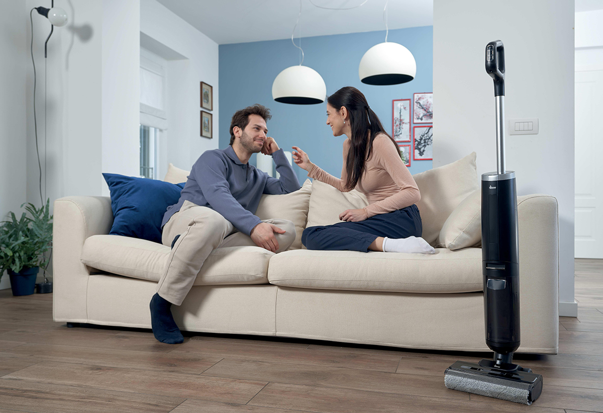 Απεικονίζεται ζευγάρι στον καναπέ. Δίπλα η σκούπα όρθια.